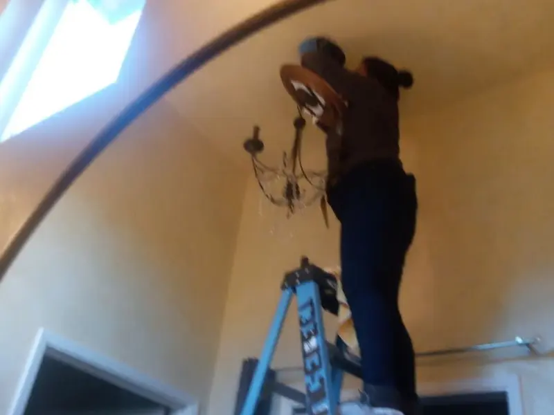 Electrician installing a chandelier in a Twin Falls residence